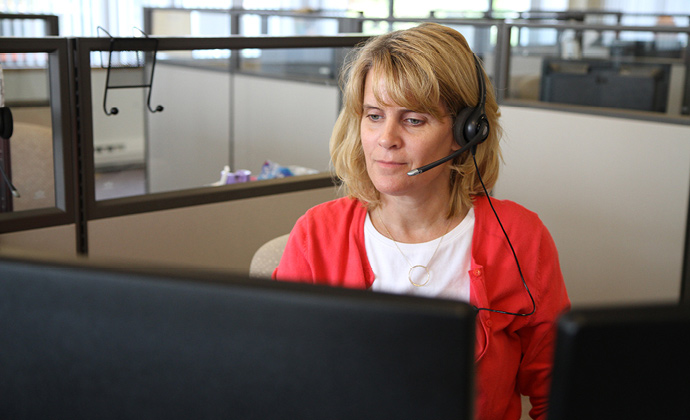 A VITAS team member answers a call at her workstation