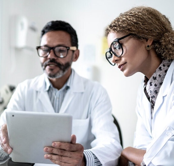 Two clinicians review information on a tablet