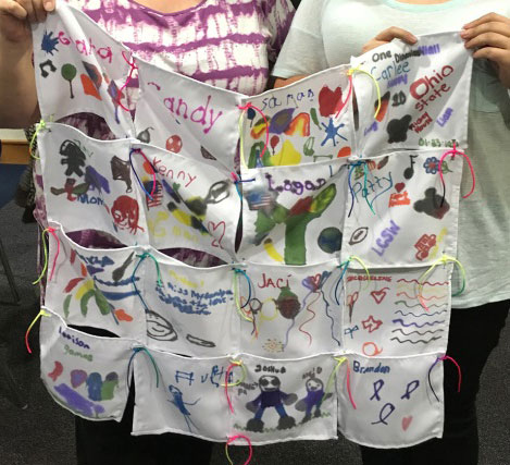 Two children hold up a remembrance quilt they helped to make