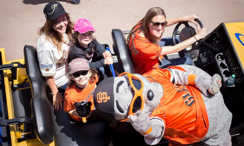 The group sits in a team vehicle with Lou Seal, the Giants mascot