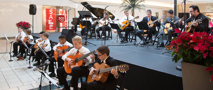 The adult and child musicians perform together