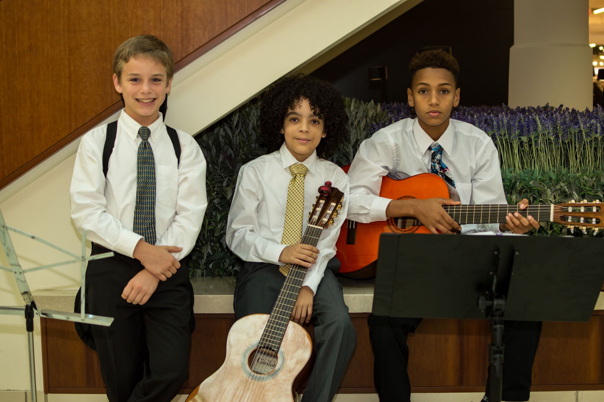 Three young men who participated in the event, two holding guitars