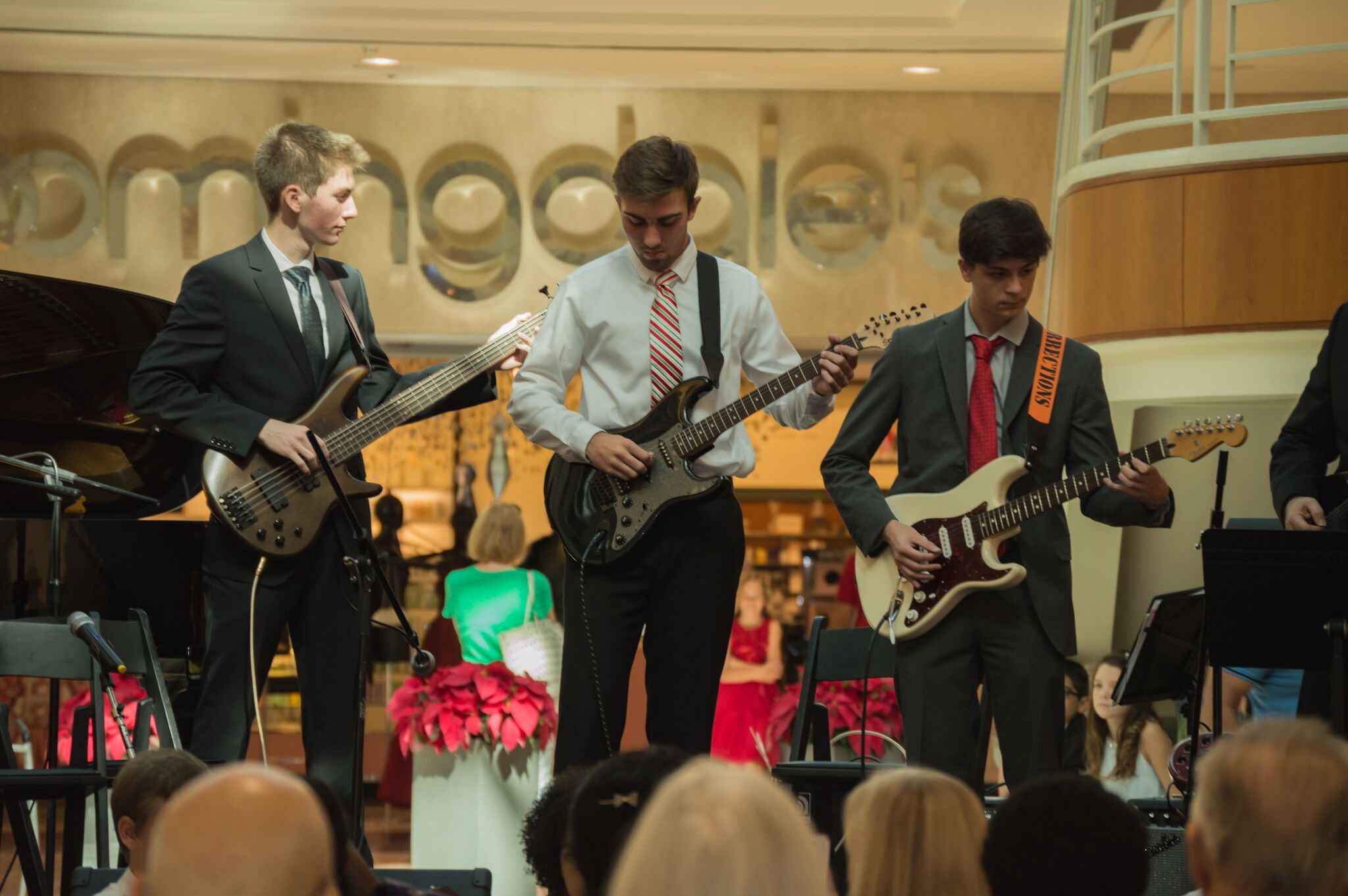 Three young men play electric guitars