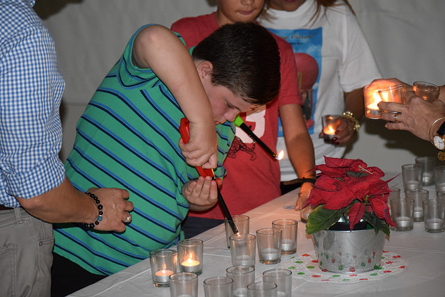 A child lights a votive candle