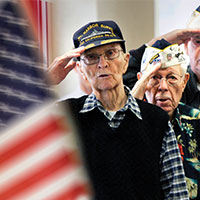 Military veterans salute the flag