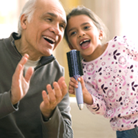 A man and child sing and clap together