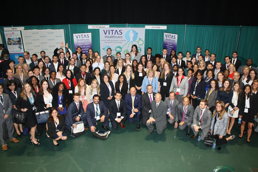 The group gathered for a photo in front of the VITAS booth