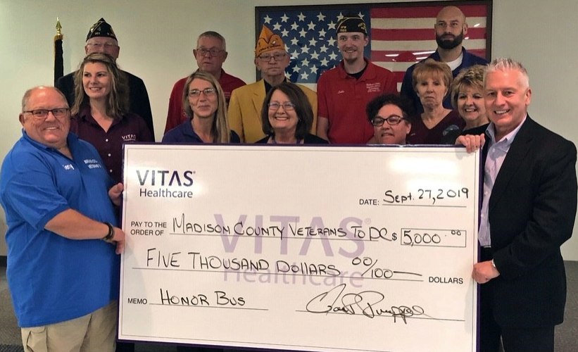 The group shows a large, ceremonial check