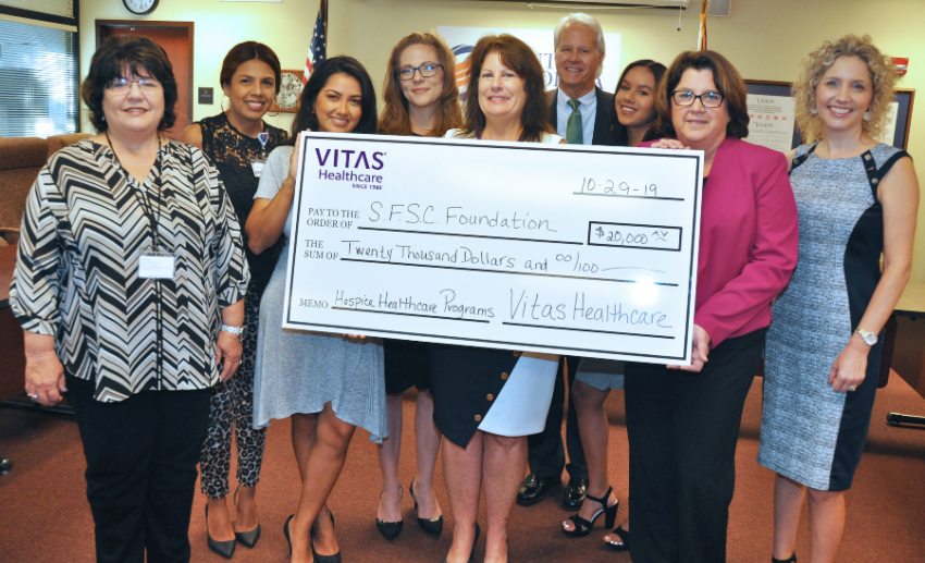 The group holds the ceremonial check