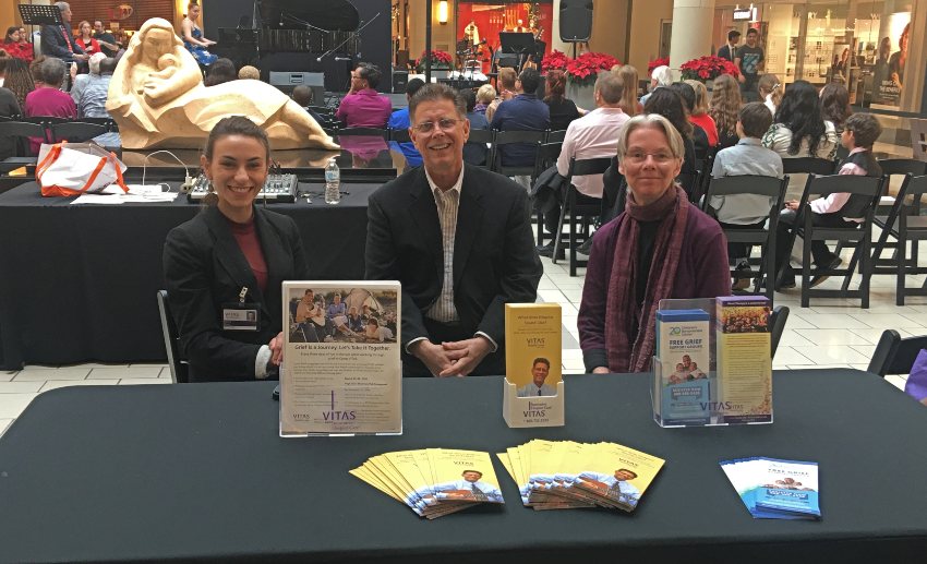 Three VITAS team members at a table with brochures behind the audience