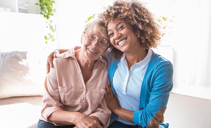 A case manager embraces a woman as they both smile