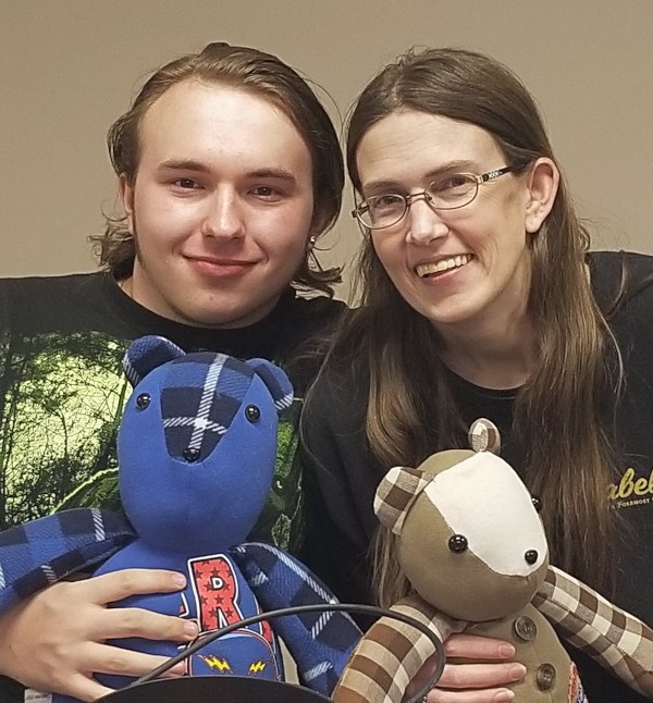 A man and woman each hold a Memory Bear sewn by VITAS volunteers