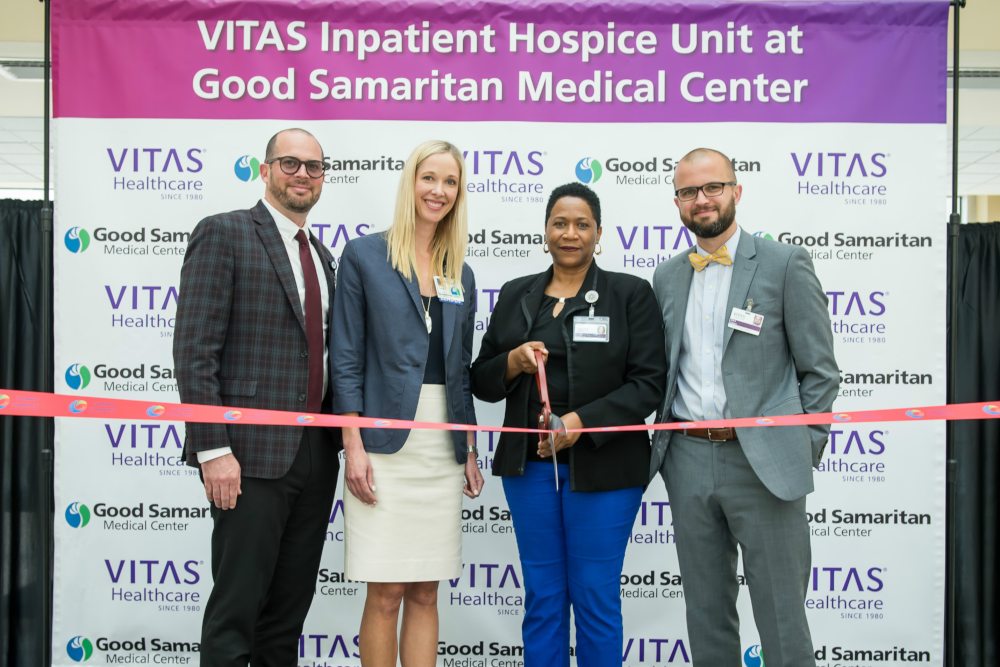 Good Samaritan and VITAS executives stand behind the ribbon with a pair of ceremonial scissors