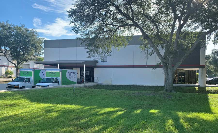 An exterior shot of the building with two delivery trucks backed into the loading dock