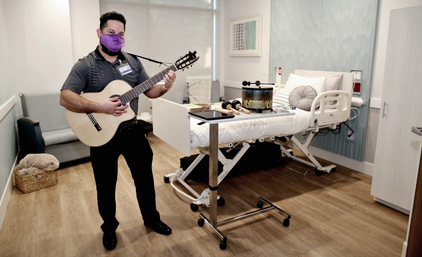 Rodolfo Reyes plays the guitar in a patient room