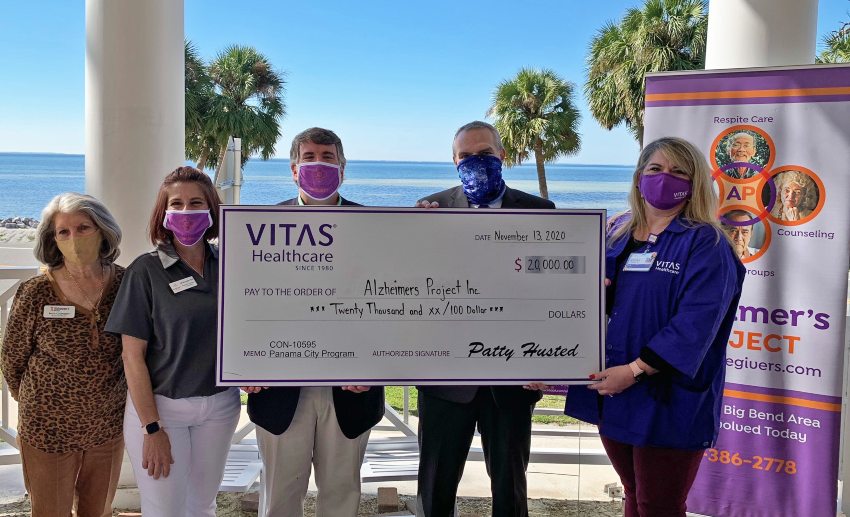 The group holds a large ceremonial check