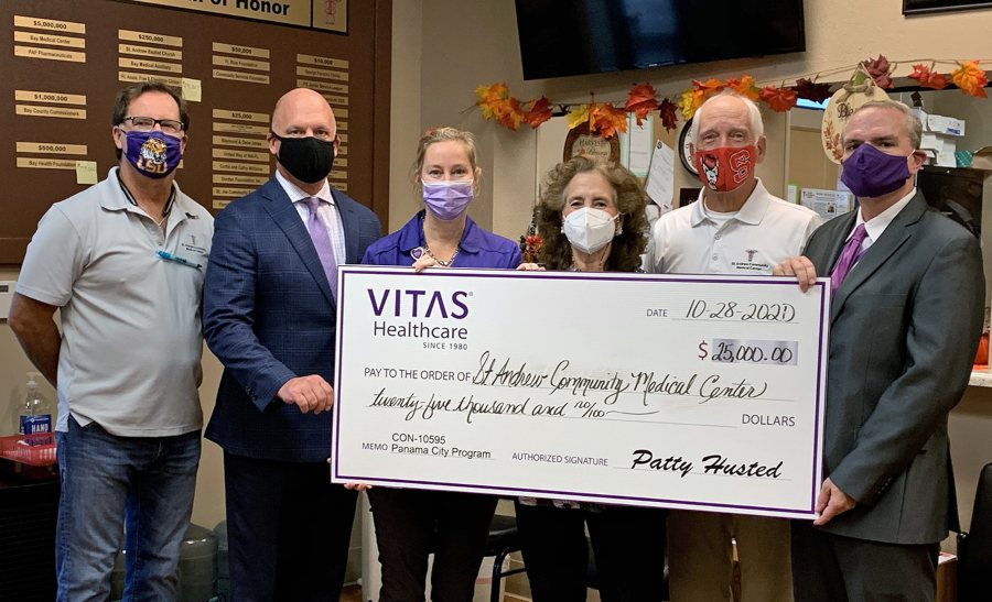 The group poses for a photo with a ceremonial check