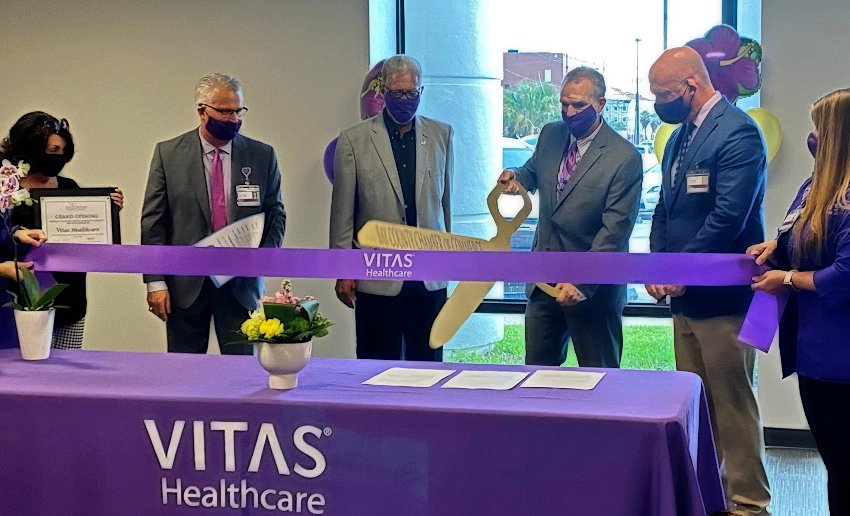 The dignitaries cut a large purple ribbon with ceremonial gold scissors