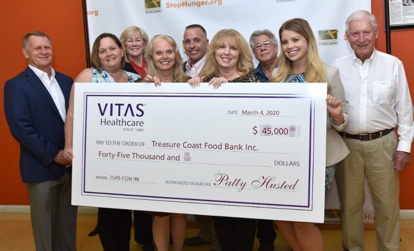 The group poses with the oversized ceremonial check