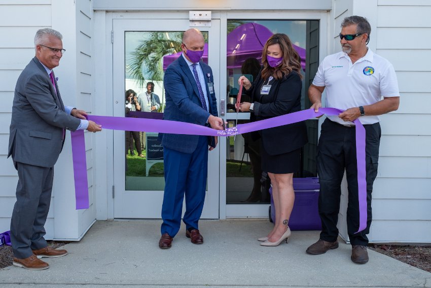 The ceremonial ribbon-cutting with purple ribbon at the entrance to VITAS Suites