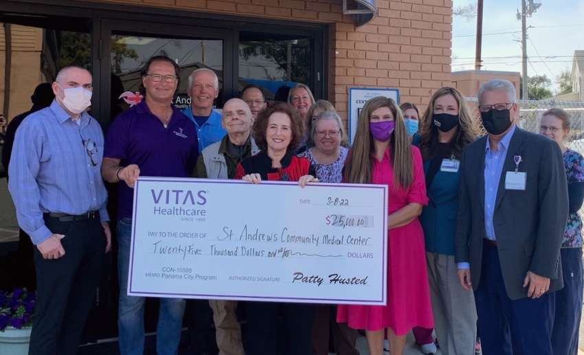 A group holds a ceremonial check outside Center of Hope Medical Clinic