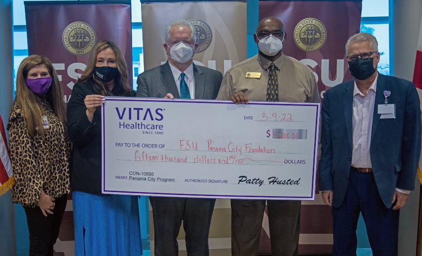 A group holds a ceremonial check at FSU Panama City