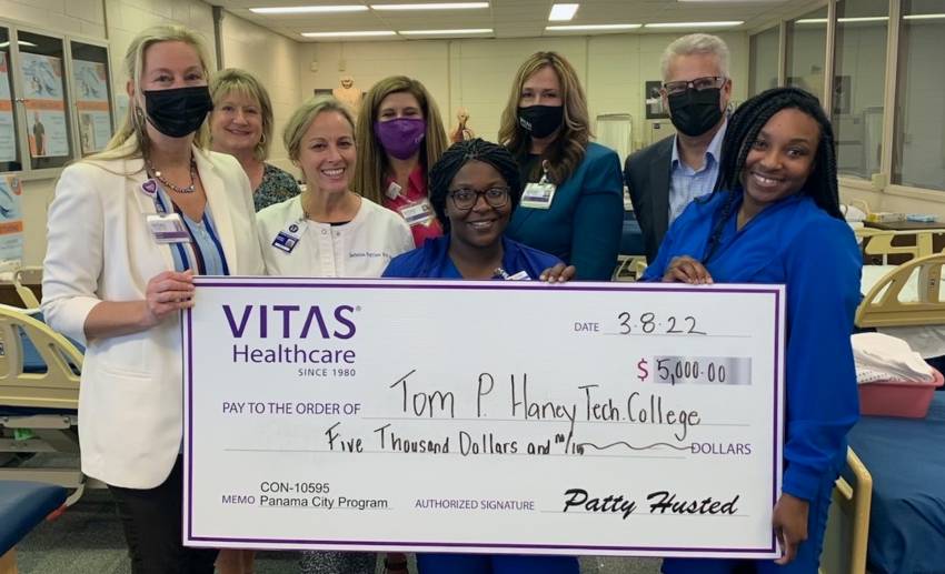 A group poses with a ceremonial check at Haney Tech