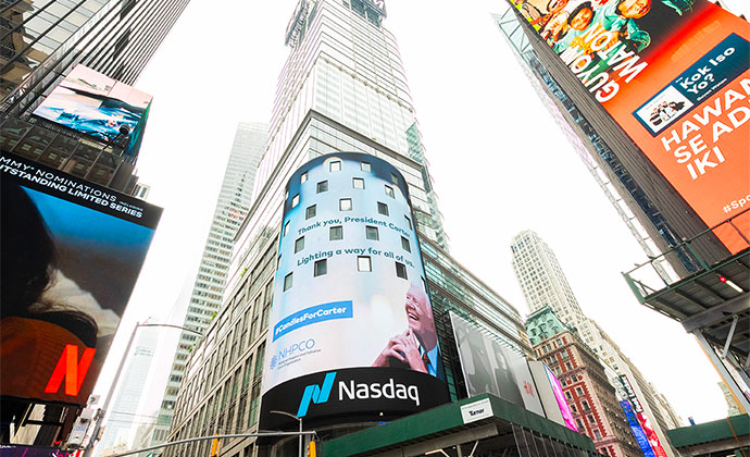 The world-famous Nasdaq screen displays a message from hospice leaders that reads, “Thank you, President Carter. Lighting a way for all of us. #CandlesForCarter.