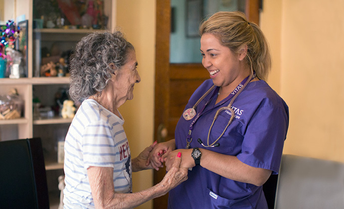 Một người phụ nữ cao tuổi cầm tay một thành viên nhóm VITAS