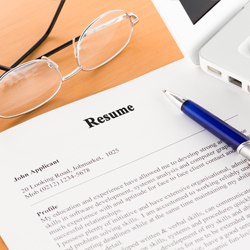 Resume with glasses and pen laid on top