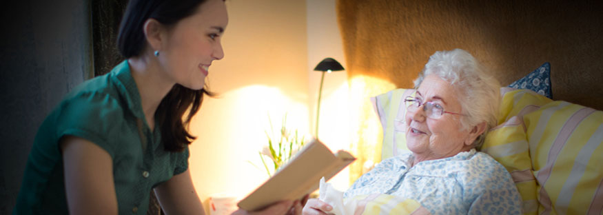 Caretaker reading to patient