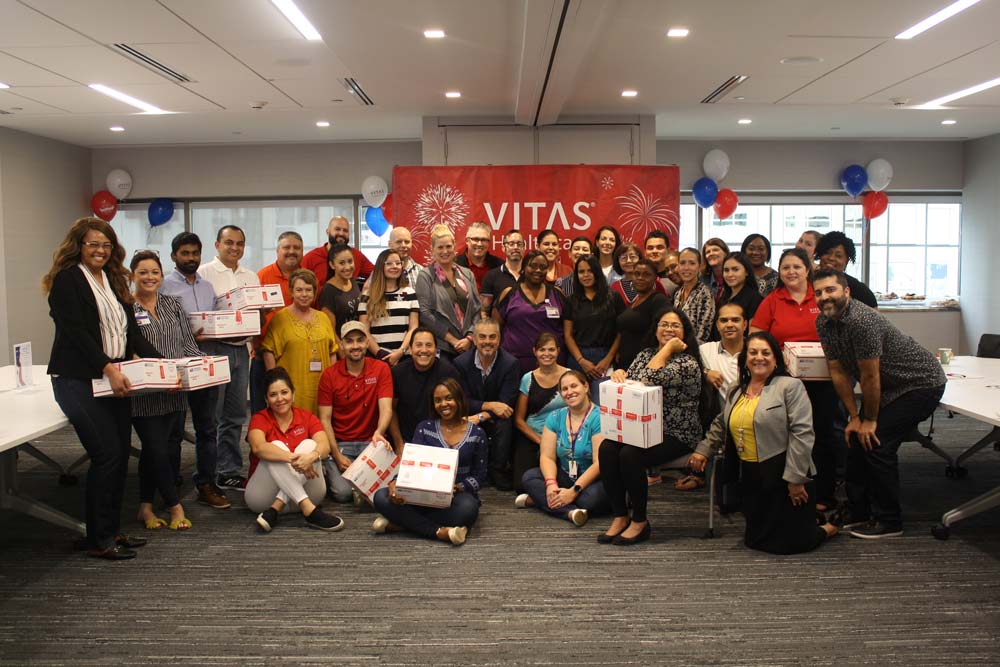 The VITAS team in a conference room with care packages and red, white, and blue balloons in the back