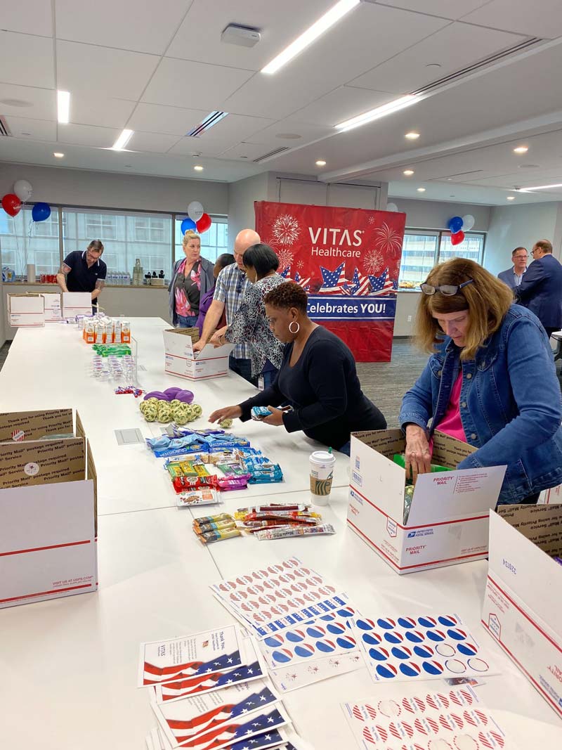 Team members place individually-wrapped snacks into the care packages