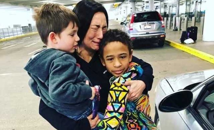 Alisa cries as she hugs her children at the airport en route to NYC