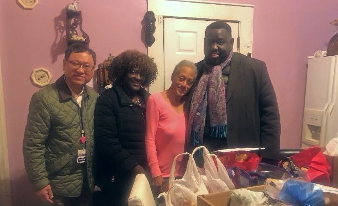 Kimiko with three members of her VITAS team at Thanksgiving, with groceries on the table for a feast