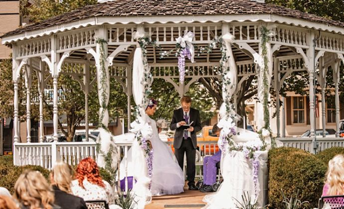 The couple say their vows in the gazebo as the officiant presides