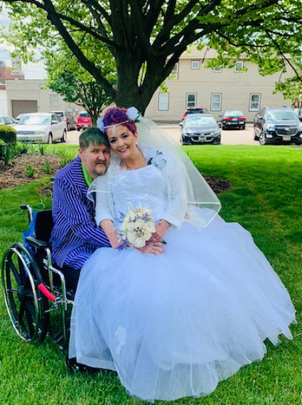 The couple posing for a portrait outside