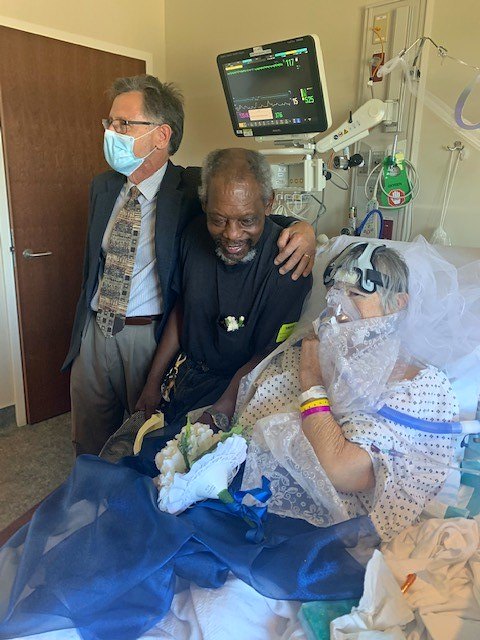 The chaplain and fiance at the bride's bedside