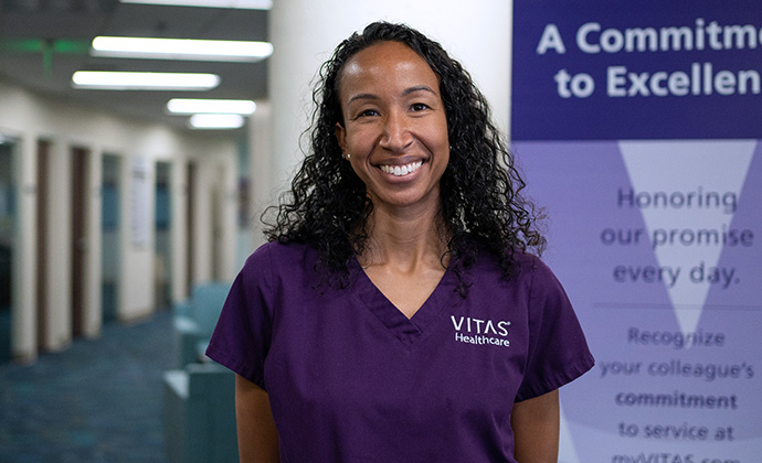 A VITAS nurse smiles in a healthcare office
