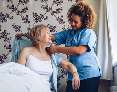 A hospice aide helps a patient