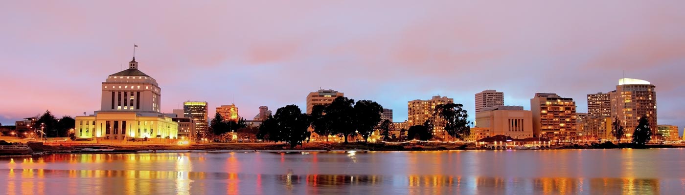 Downtown Oakland skyline along the banks of Lake Merritt at dusk