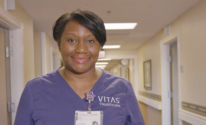 A VITAS team member smiles in the corridor of an inpatient hospice unit