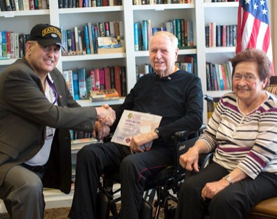 A VITAS veteran patient receives a certificate as his wife looks on