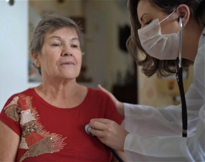 A clinical team member checks a patient's breathing with a stethoscope