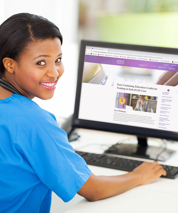 A nurse uses a desktop computer to register for a VITAS webinar