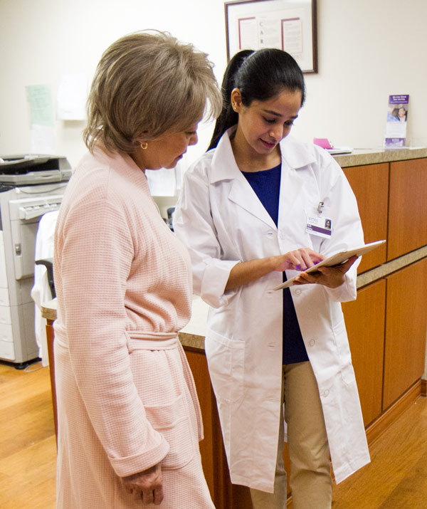 A physician shows information to a patient on a tablet