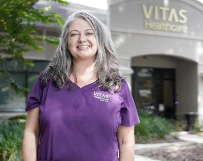 Una enfermera de VITAS sonríe afuera de una oficina de VITAS