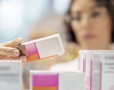 A clinician looks at a box of medication