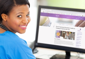 A healthcare professional views VITAS webinars on a desktop computer