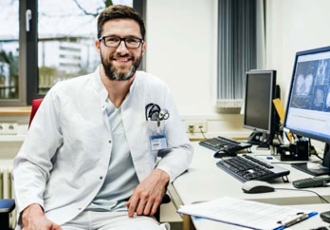 A clinician at his computer in an office